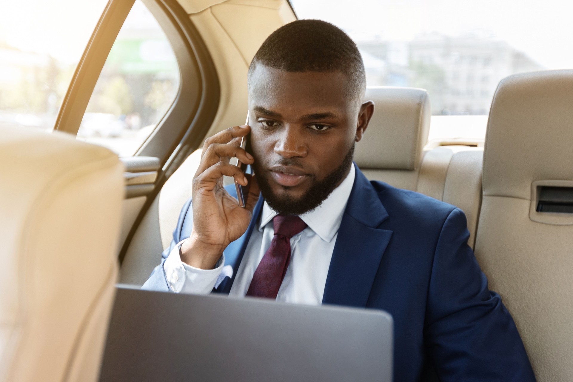 Empresário trabalhando em laptop, usando smartphone enquanto vai para o aeroporto